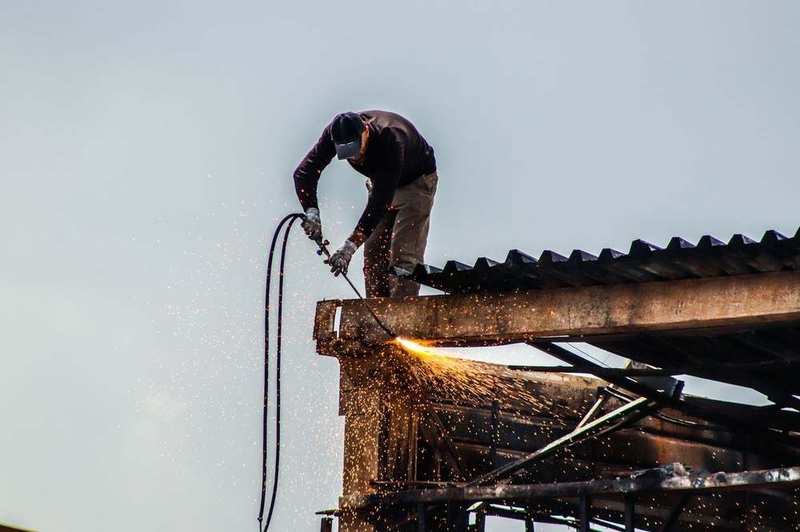 PRS roofer cutting metal roofing on a Perth roof